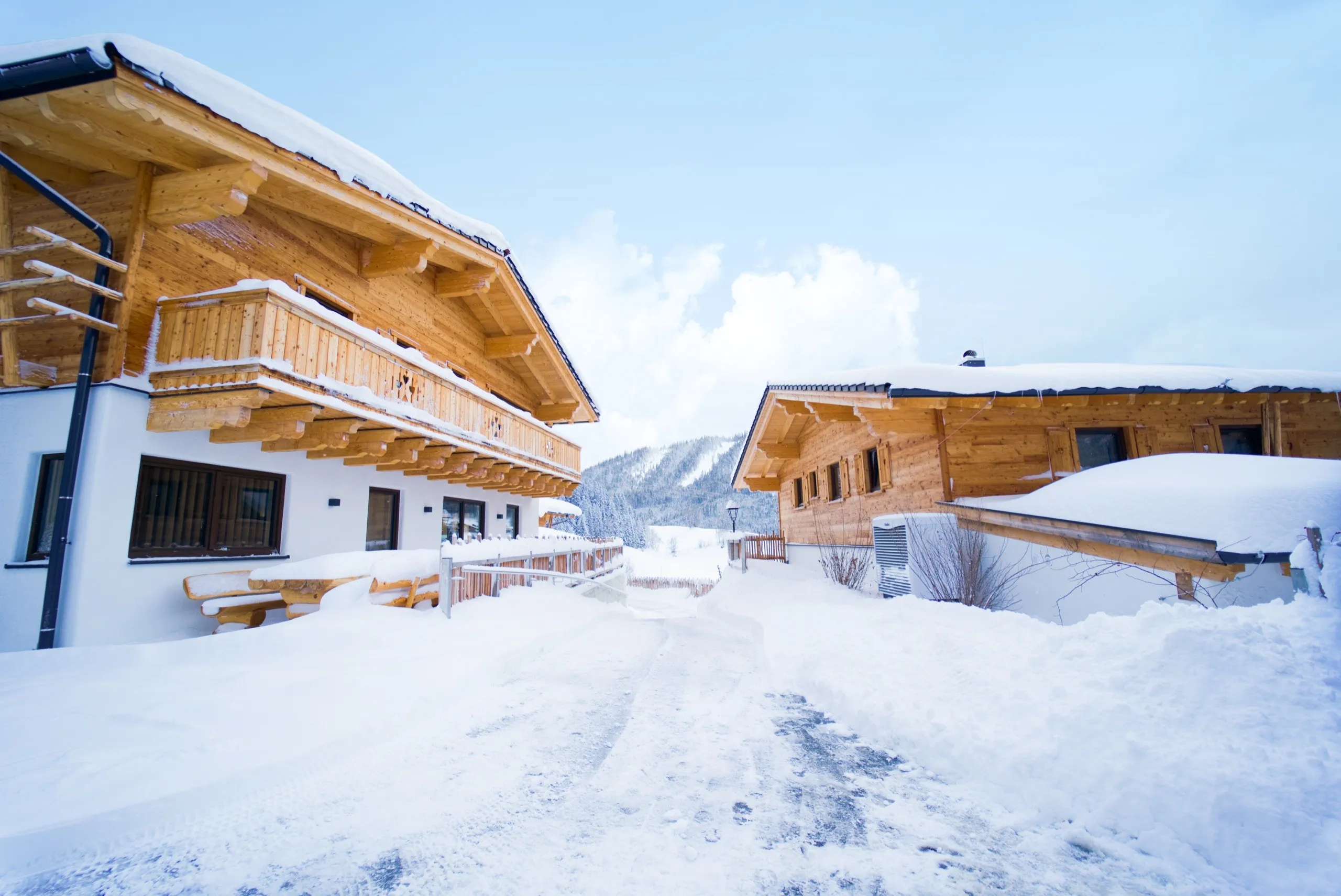 Verschneite Dorfstraße zwischen den Chalets