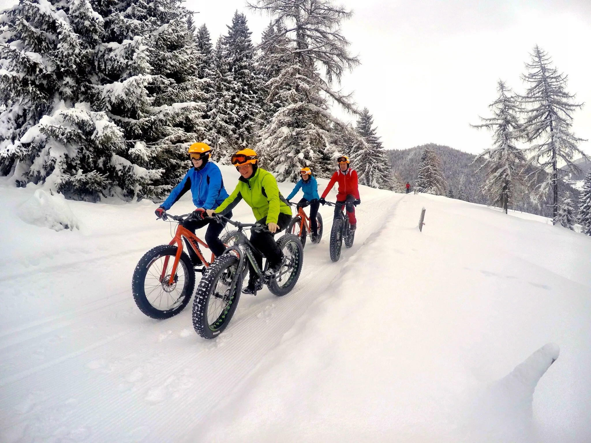 Fatbiker auf einem verschneiten Weg im Winterwald
